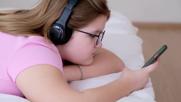 Kulaklıklı Rahat Genç Kız Internette Sörf Yaparken Müzik Dinliyor Gözlüklü — Stok video