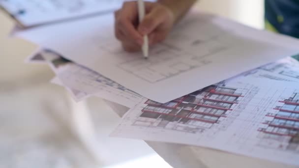 Doświadczony Inżynier Korygujący Plan Renowacji Stoi Pobliżu Sprzętu Bezpieczeństwa Budowlanego — Wideo stockowe