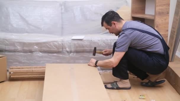 Maßgeschneiderte Möbelmontagemeister Overalls Hämmern Nägel Holzplatten Hocken Auf Dem Boden — Stockvideo