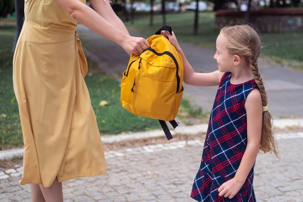 Młoda Matka Żółtej Sukience Daje Uczennicy Plecak Mała Dziewczynka Długimi — Zdjęcie stockowe