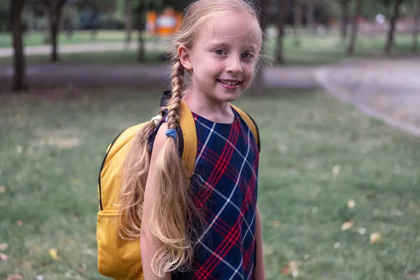 귀여운 여학생은 머리를 긍정적인 아이에게 가을에 과정에 반환에 노란색 배낭과 — 스톡 사진