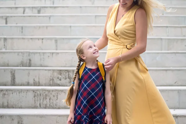 Cute Blonde Schoolgirl Bright Dress Looks Mother Smiling Joyfully Standing — Stock Photo, Image