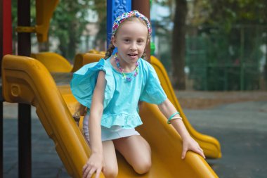 Neşeli genç bir kız, çocukların oyun parkındaki labirentte neşeyle geziniyor, oyun oynamanın keyfini kucaklıyor.. 