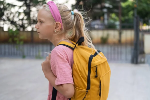 Uczennica Różowa Sukienka Słonecznym Żółtym Plecakiem Pobliżu Szkoły Podstawowej — Zdjęcie stockowe