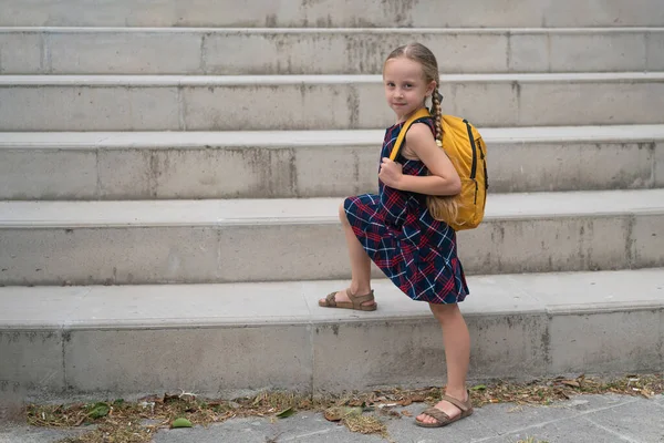 Żółtym Plecakiem Promiennym Uśmiechem Wesołą Uczennicą Sukience Szkoły Jej Portret — Zdjęcie stockowe