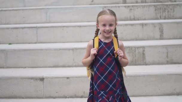 Lächelndes Kleines Mädchen Karierten Kleid Mit Rucksack Steht Neben Steinstufen — Stockvideo