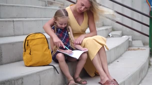 Vorsichtige Mutter Hilft Kleiner Tochter Bei Hausaufgaben Auf Steintreppe Stadion — Stockvideo