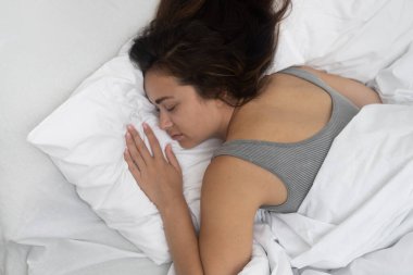 Dinlenen kadın, modern ev hanımlarının yatak odalarında açık renkli yataklarla derin bir uykuya dalıyor rüyalardan zevk alıyor gece uykusundan enerji alıyor.