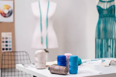 Makrome elbise örmek için bobin boyası. Moda dükkanında masa örmek için. Atölye içi boş dikiş atölyesindeki terzi masasında malzeme ve malzemeler.