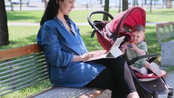 Mujer Concentrada Usando Ordenador Portátil Para Tareas Trabajo Mientras Bebé — Vídeo de stock
