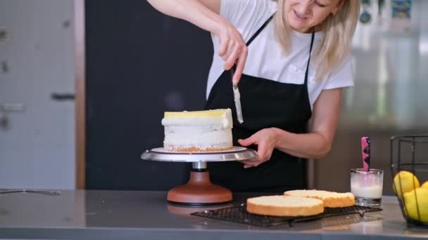 Zadowolony Cukiernik Uśmiechnięty Podczas Smarowania Warstw Ciasta Świeżą Organiczną Blondynką — Wideo stockowe