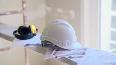 İnşaat güvenlik ekipmanları ve ofis yenileme işlemleri için eski püskü duvarı işlemeden önce beyaz koruyucu başlık takan mühendis.