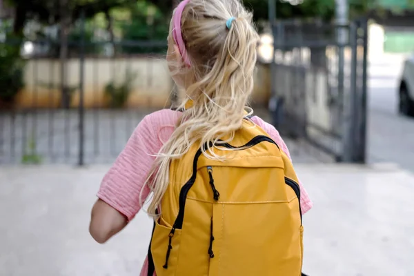 Mała Dziewczynka Plecami Nas Nosi Spory Żółty Plecak Poruszający Się — Zdjęcie stockowe