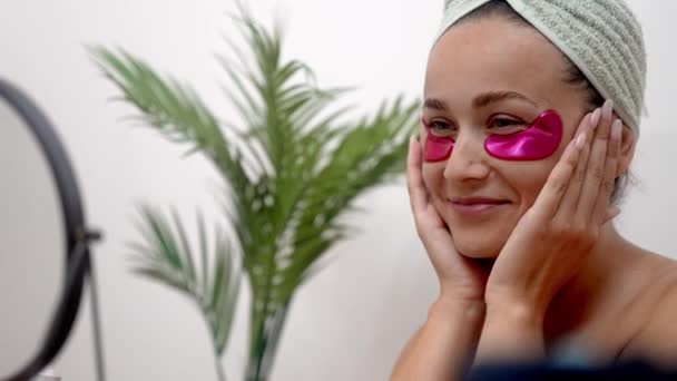 Ακτινοβολία Μια Γυναίκα Εφαρμόζει Ροζ Αυτοκόλλητα Κάτω Από Μάτια Αγκαλιάζοντας — Αρχείο Βίντεο
