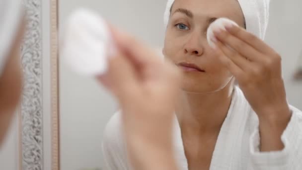 Mulher Roupão Perto Espelho Concentra Autocuidado Limpando Suavemente Pele Com — Vídeo de Stock