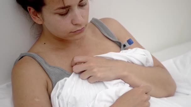 Haar Ziekbed Een Vrouw Beoordeelt Haar Lichaamstemperatuur Met Een Thermometer — Stockvideo