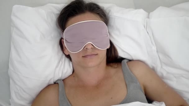 静かな女性 睡眠のためにマスク 安らかに居心地の良い毛布の下の枕の上に休息 彼女の健康的な睡眠療法のシンボル — ストック動画