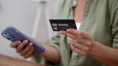 Verimli e-alışveriş: Neşeli bir kadın telefonuyla ödeme yapar, kusursuz bir çevrimiçi alışveriş deneyimi sağlar. 