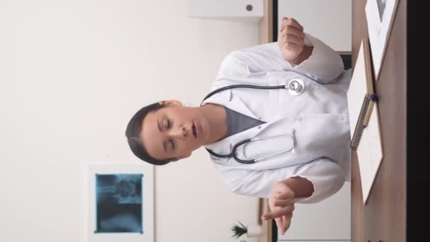 女性医師がカメラにジェスチャーし オンライン予約中に患者と話す — ストック動画