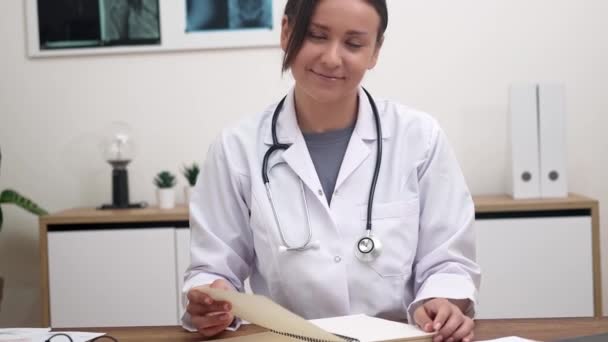 Leende Kvinnlig Läkare Tittar Kameran Sitter Vid Bordet Kontoret Med — Stockvideo
