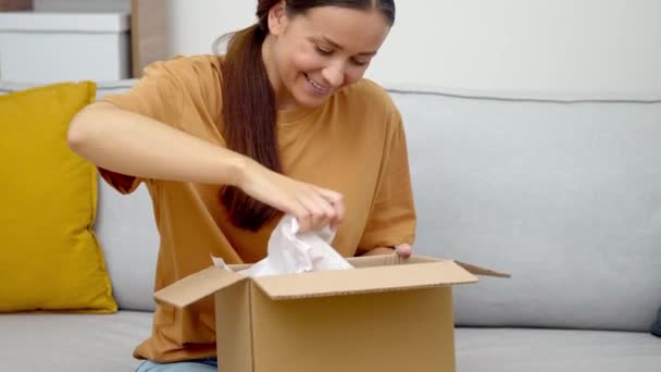 Digital Retail Joy Своем Диване Веселая Женщина Распаковывает Свою Посылку — стоковое видео