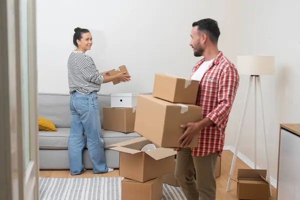 Home ownership: couple smiles shine as they pack boxes during move into their mortgaged home