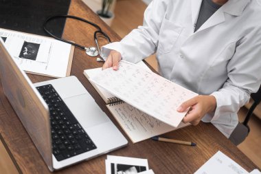 Beyaz laboratuvar önlüklü kadın doktor, üst düzey tıbbi belgelere bakıyor. Tıp uzmanı, modern klinikteki sağlık hizmetlerinin sonuçlarıyla çalışıyor.