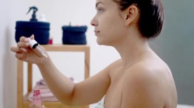 Ayna anı: Bir kadın, evine hyaluronik asit uygulamak için serum düşürücü kullanarak yaşlanmayı önleyici cildini geliştirir. 