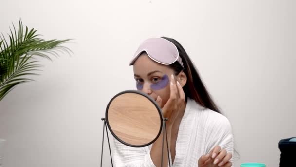 觉醒之美 一个女人在处理浮肿 皱纹和黑眼圈时 早上的例行公事会展开 一边戴着眼罩一边凝视着镜子 — 图库视频影像