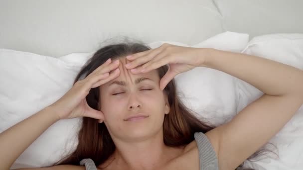 Depresyondaki Genç Kadın Yatakta Uzanıp Gözlerini Kapatıyor Şakaklara Parmaklarını Bastırıyor — Stok video