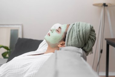 Tranquil Lounge: Bornozuna sarılı olarak, rahat bir kanepeye uzanarak, spa seansı sırasında yüz nemlendirici bir maskenin sükunetini kucaklıyor.. 