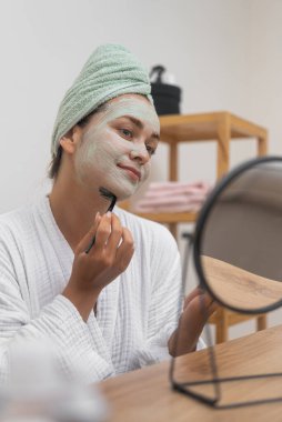 Deri Mükemmelliği: Banyo yaptıktan sonra, havluyla, yaşlanmayı önleyici, susuz bırakma ve kusursuz cilt için yüz maskesi takıyor.. 