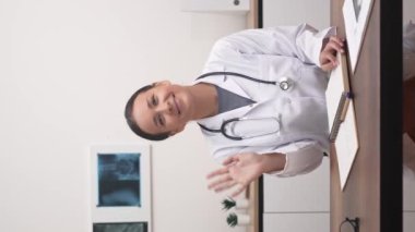 Sanal Sağlık Sağlayıcı: kadın doktor, video ekranı, webcam 'e el sallama, tele-sağlık kavramını örnekleme. 