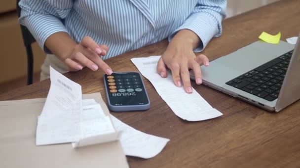 一位女士在家里拿着帐单 用她的笔记本电脑上网付款 她计算税收 审核帐目和贷款利率 — 图库视频影像