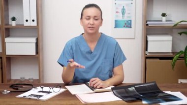 TeleHealth Professional: Masasında, kamerayla konuşan bir kadın doktor, teletıp devrimini sembolize ediyor.. 