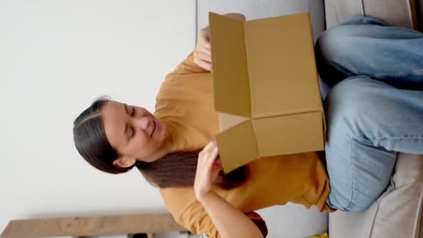 미소로 여자는 그녀의 패키지를 온라인 주문에서 새로운 헤드폰으로 그녀의 만족을 — 비디오