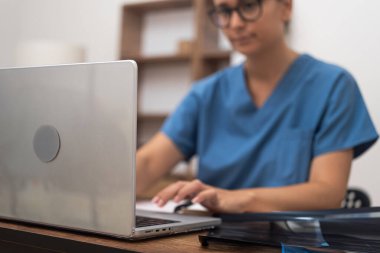 Dijital Tıbbi Danışmanlık: Bilgisayarındaki bir kadın doktor, tıbbi yardım sunarak ve video konferansları düzenleyerek sağlık hizmetleri sunuyor.