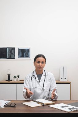 Sanal Danışmanlık: kadın doktor kameraya hitap ediyor, online randevular sırasında hastalarla konuşuyor. 