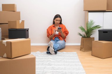 Güzel bir kadın, elinde telefon karton kutularla, yakın arkadaşlarına, şehirde yeni teknolojilerle modern bir eve taşınma ihtimalini anlatıyor.