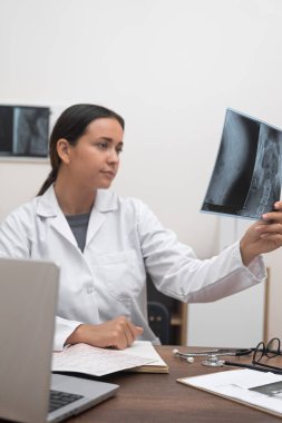 Hasta bakımı: Sağlık hizmetlerinin sağlanmasında, bir doktor hastaya hastalık teşhisi koyarak radyolojik bir röntgen filmi kullanır..