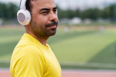 Açık şehir spor stadyumundaki spor adamının portresi. En sevdiği şarkı kablosuz kulaklıkla çalınıyor.. 