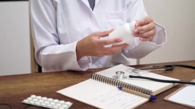 Kadın doktor elinde bir kavanoz hapla internet kamerasına danışmanlık yapan sanal bir hastayla konuşuyor. Teletıp, tele sağlık konsepti. 
