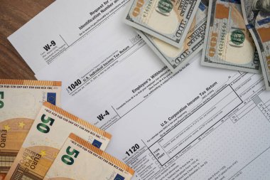 Dolar ve avro banknotları, vergi mükelleflerinin yasalara uygun cezalardan kaçınarak yıllık gelirlerini zamanında bildirmeleri için gereken farklı vergi formlarına dayanmaktadır.