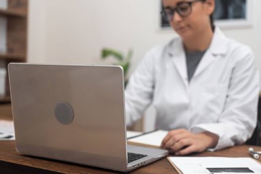 Teletıp Uzmanlığı: Kendini bilgisayarına adamış bir kadın doktor, tıbbi destek sağlıyor ve tele-sağlık merkezini somutlaştıran video istişareleri gerçekleştiriyor..