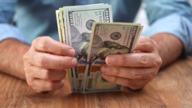 CEO, yazılım şirketinin yenilikçi proje geliştirme ve genişlemesinin bir sonraki aşamasını finanse etmek için gereken nakit akışını hesaplayarak ofisinde dolar banknotları sayıyor.