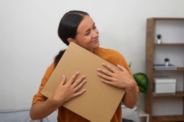 delighted woman clutches her parcel, embodying online shopping satisfaction as her long-awaited delivery arrive clipart