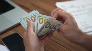 Yaşlanan adam, banknotların toplam miktarını sayarak banknotları açıyor. Olgun çalışan, Amerikan döviz kurlarını yavaş çekimde izleyerek nakit hesaplıyor.