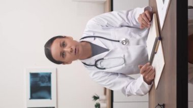 Sanal Danışmanlık: kadın doktor kameraya hitap ediyor, online randevular sırasında hastalarla konuşuyor. 