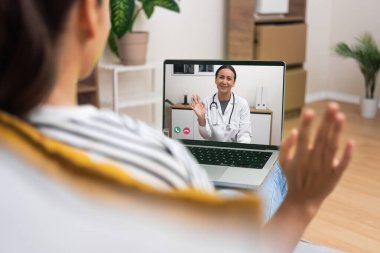 Genç bir kadın doktoruyla arkadaşça bir video görüşmesi yapıyor, tele-sağlıktaki kişisel dokunuşları vurguluyor..