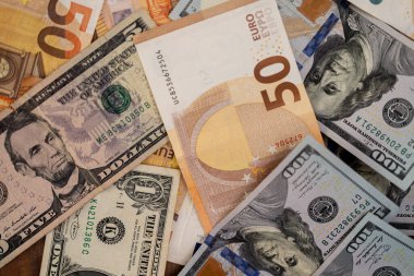Avro banknotlarının masaya konduğu dolar banknotları küresel para sisteminde baskın para birimlerinin döviz kurlarında sıkı bir korelasyon kavramını ortaya koyuyor